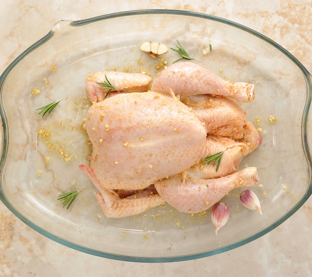 Poulet entier cru sur une table en marbre