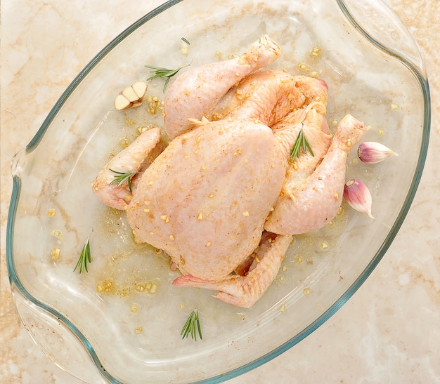 Poulet entier cru sur une table en marbre