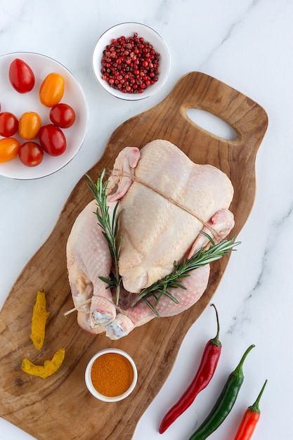 Poulet entier non cuit aux herbes et épices