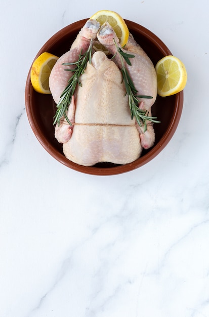 Poulet entier non cuit aux herbes et épices