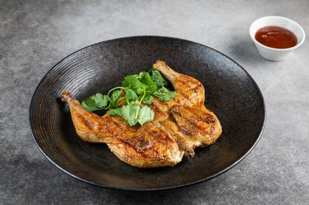 Poulet entier rôti frit grillé avec gros plan de citron au thym sur une ardoise sur la table