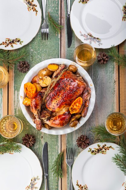 Poulet entier rôti de Noël avec pommes de terre et mandarines