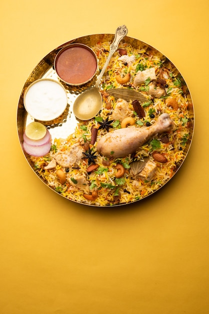 Poulet épicé Biryani de style restaurant servi avec Raita et Salan, nourriture non végétarienne populaire indienne ou pakistanaise