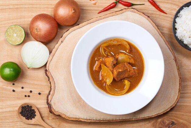 Poulet épicé et riz sur fond de bois