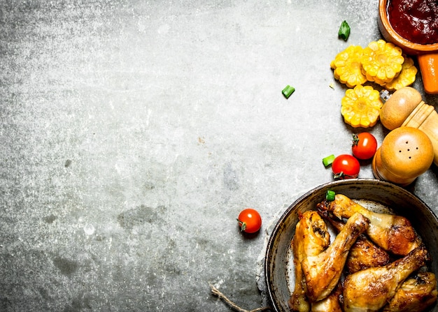 Poulet frit aux légumes et sauce tomate. Sur un fond de pierre.