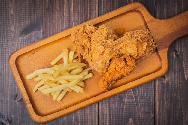 Poulet frit croustillant et pommes frites sur plaque de bois