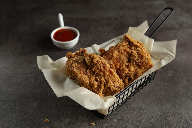 poulet frit croustillant avec sauce aux tomates sur fond noir