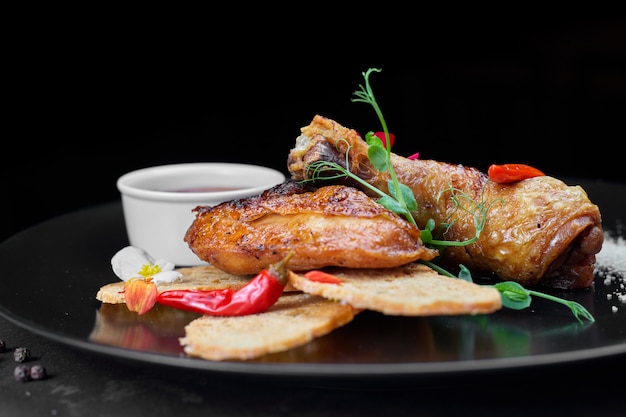 Poulet frit, avec croûtons et sauce, sur fond noir