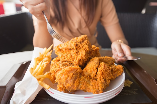 Poulet frit dans la main de la jeune femme