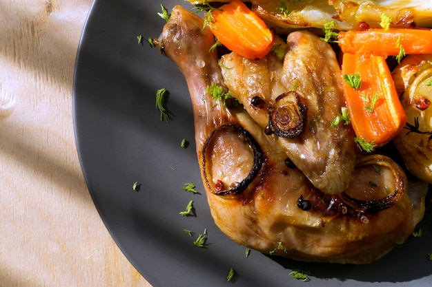 Poulet frit avec des légumes. sur une plaque grise.