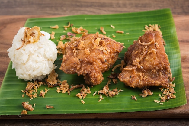 Poulet frit et riz gluant sur une feuille de bananier.