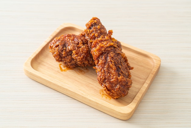 poulet frit avec sauce coréenne épicée sur plaque de bois