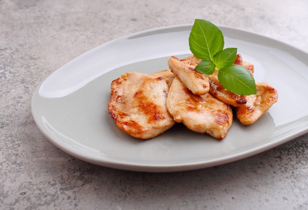 Poulet frit à la sauce soja sur une assiette décorée de graines de sésame