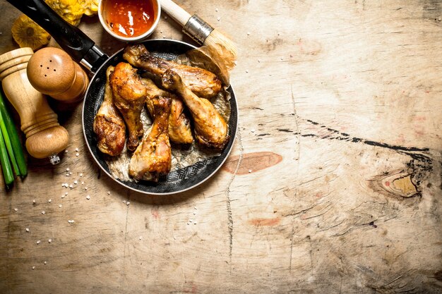 Poulet frit à la sauce tomate sur une table en bois