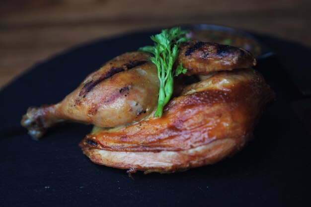 Poulet grillé sur fond de bois plat noir