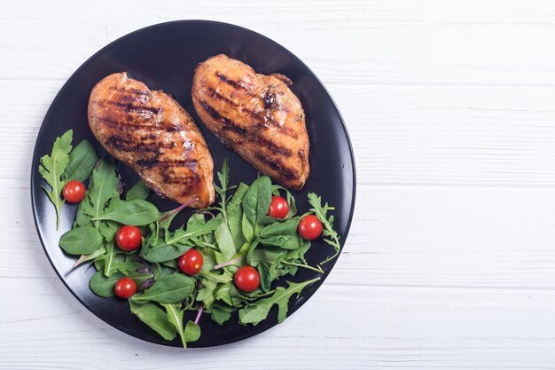 Poulet grillé avec salade d'épinards et de tomates fond de nourriture BBQ