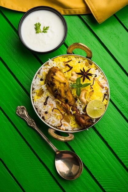 Poulet Hyderabadi ou dum biryani, servi dans un kadhai ou un bol avec une trempette au yogourt. mise au point sélective