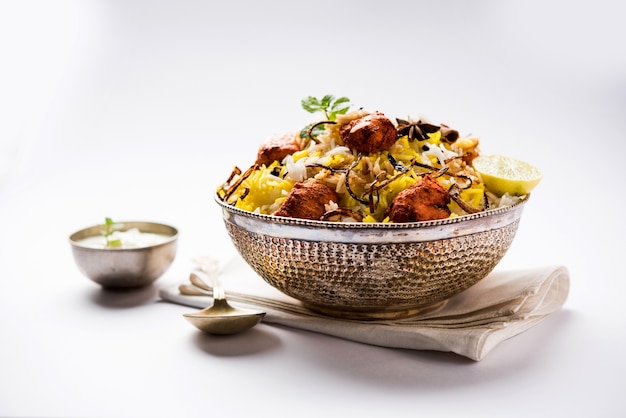 Poulet indien Tikka Biriyani servi dans un bol avec du yaourt. mise au point sélective