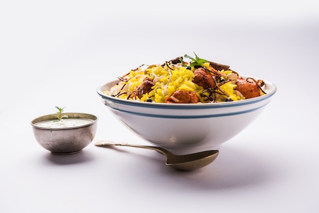 Poulet indien Tikka Biriyani servi dans un bol avec du yaourt. mise au point sélective