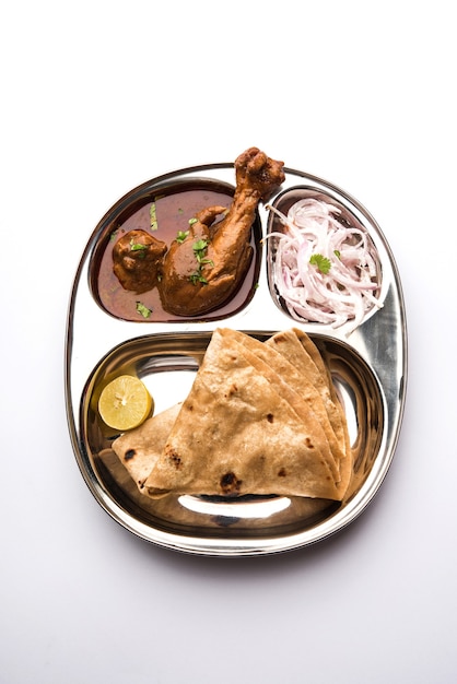 Le poulet Kolhapuri Thali est un plat indien populaire composé de viande de volaille, d'œufs au curry avec du chapati, de riz, de salade et de Gulab Jamun sucré