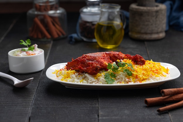 Poulet Mandi Biryani disposé dans une faïence avec fond noir ou texture