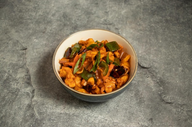 Poulet avec noix de cajou servi dans un plat isolé sur le fond vue supérieure de la nourriture bangladaise