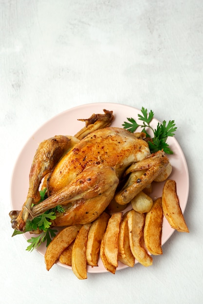 Poulet rôti appétissant avec pommes de terre à l'ail et oignons