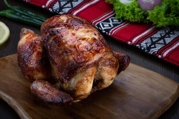 Poulet rôti ou grillé servi dans une planche de bois isolée sur la vue de dessus de table de la nourriture arabe