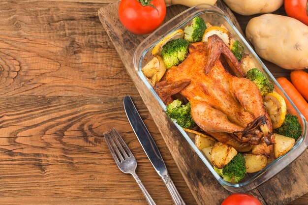 Poulet rôti et légumes sur table en bois