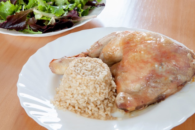 Poulet rôti avec riz et salade.