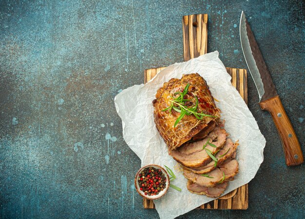 Photo poulet roulé rôti avec des épices et des herbes sur du papier à cuire