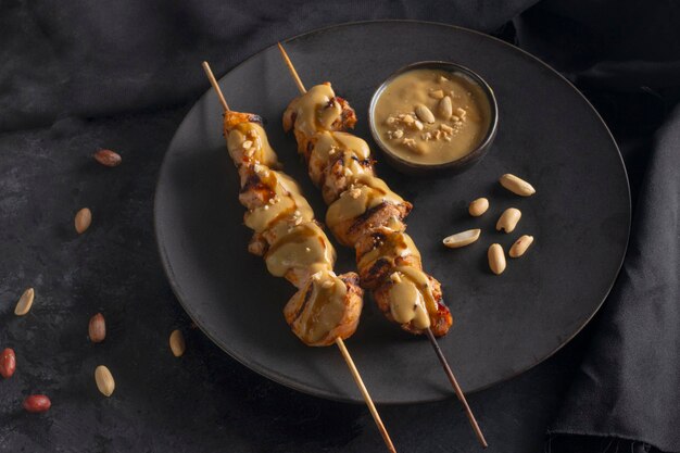 Poulet satay dans une assiette noire