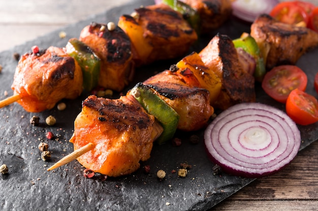 Poulet shish kebab avec légumes sur table en bois se bouchent