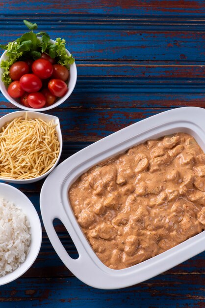 Poulet stroganoff accompagné de riz, salade et paille de pommes de terre.