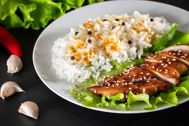 Poulet teriyaki fait maison avec riz blanc et poivre sur fond noir