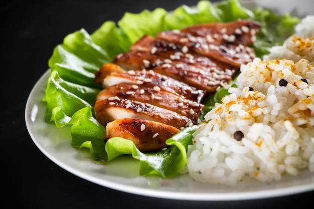 Poulet teriyaki fait maison avec riz blanc et poivre sur fond noir