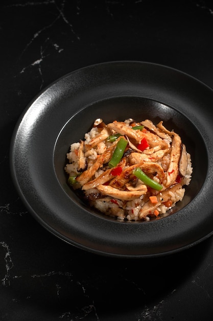 Poulet teriyaki avec garniture riz japonais poivron shiitake champignons sur fond sombre