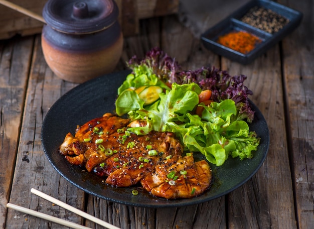 POULET TERIYAKI servi dans un plat isolé sur fond de bois Vue latérale du Teppanyaki