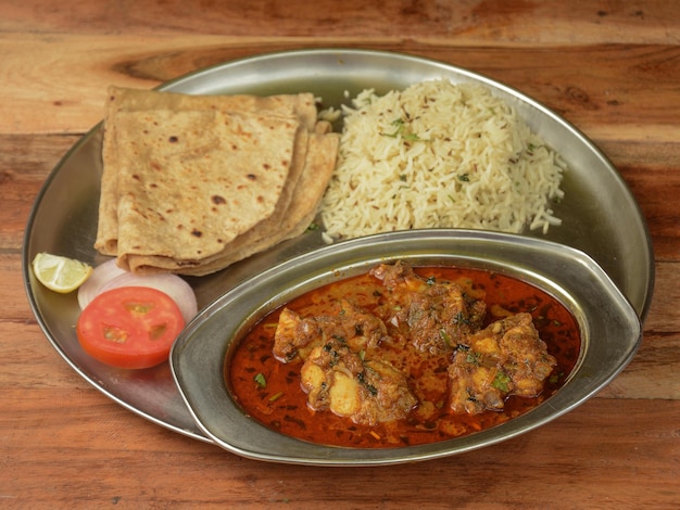 Le poulet Thali d'un plateau de cuisine indienne se compose de poulet au curry jeera riz roti et oignons selective focus