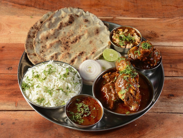 Poulet Thali spécial d'un plateau de cuisine indienne se compose de lentilles au curry de poulet roti de riz jeera et d'oignons mise au point sélective