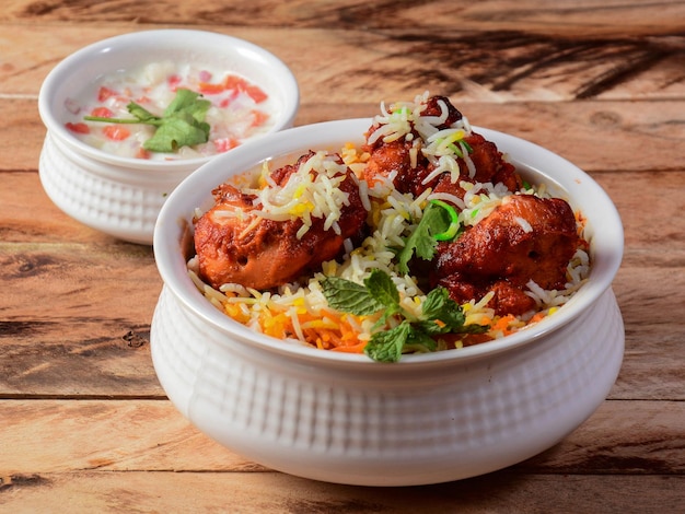 Photo poulet tikka biryani fait de riz basmati cuit avec des épices masala servi avec une mise au point sélective de yogourt