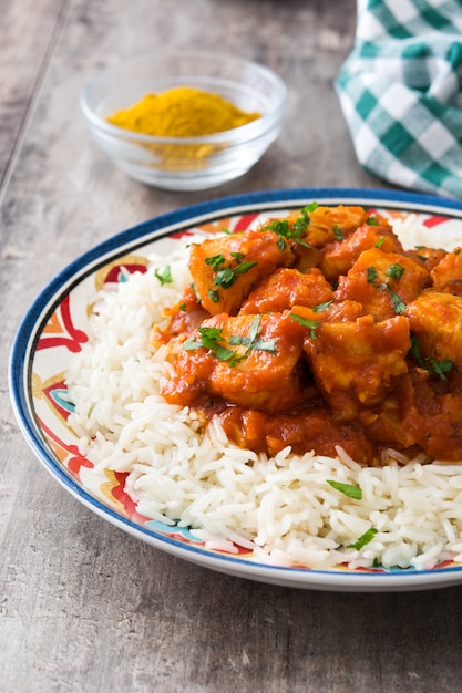 Poulet tikka masala avec riz sur table en bois