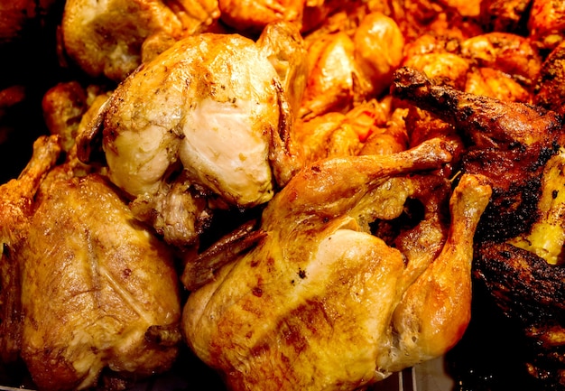 Poulets grillés cuits, poulet entier frit, beaucoup empilés en vrac, au supermarché.