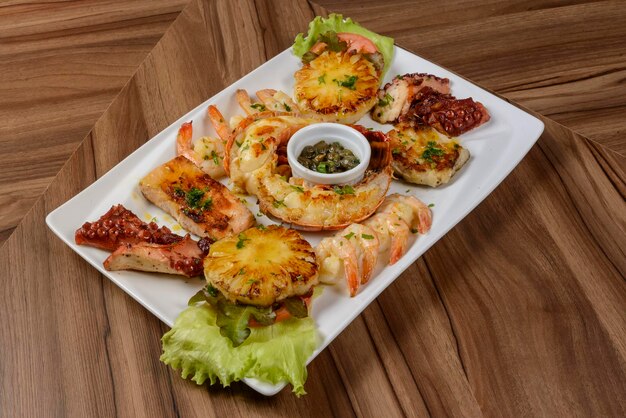 Poulpe de crevettes de homard de fruits de mer et poisson dans un bol blanc sur une table en bois Nourriture brésilienne