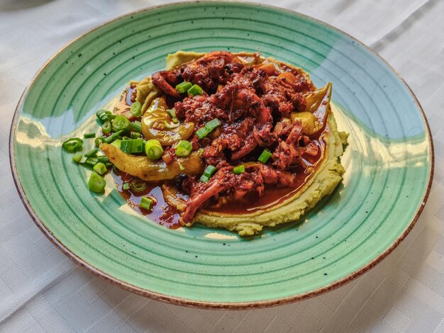 Poulpe cuit à la tomate et à la bouillie de pois cassés vue de dessus servi plat de fruits de mer