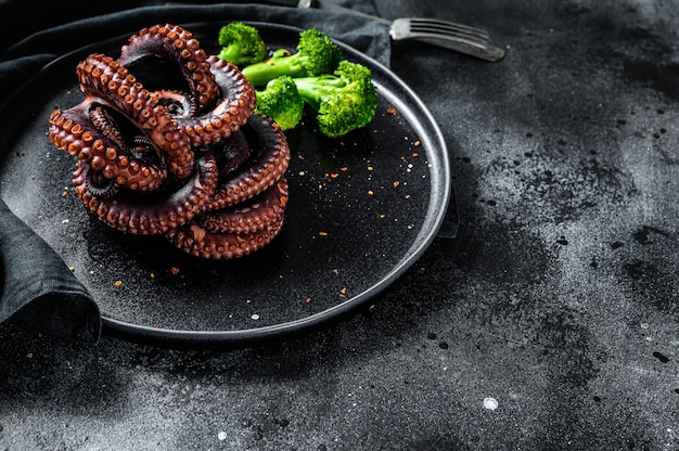 Poulpe entier grillé au brocoli dans une assiette. Vue de dessus. Espace copie