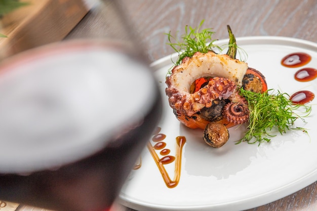 Poulpe grillé avec un verre de vin rouge