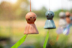 Photo la poupée au visage souriant en céramique se balance dans le vent