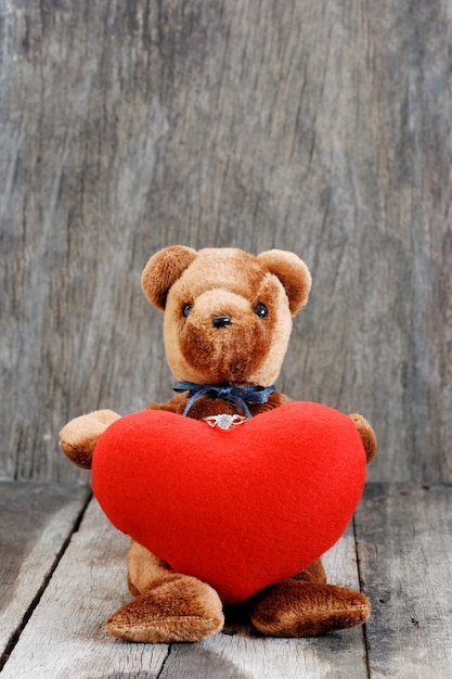 Photo poupée ourson et la bague avec un coeur rouge.