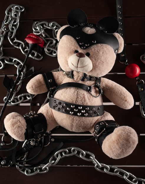 Pour le BDSM un ours en peluche habillé de ceintures en cuir et un masque est un accessoire